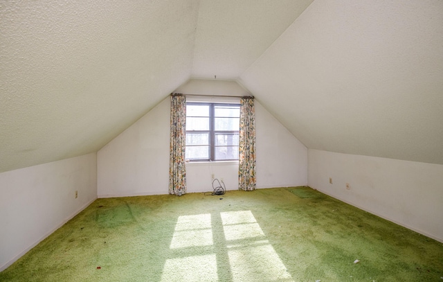 bonus room featuring lofted ceiling, carpet, and a textured ceiling