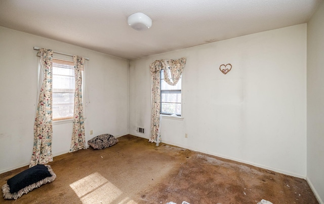 unfurnished room featuring a wealth of natural light and visible vents