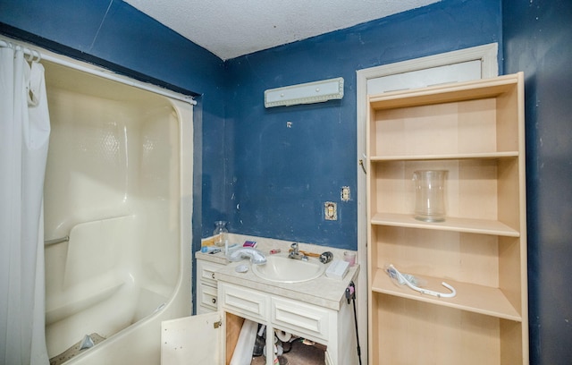 bathroom with a textured ceiling, tub / shower combination, and vanity