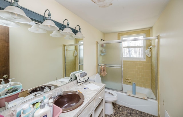 bathroom featuring enclosed tub / shower combo, vanity, and toilet