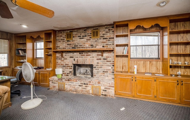 living area featuring carpet floors, a brick fireplace, and wooden walls