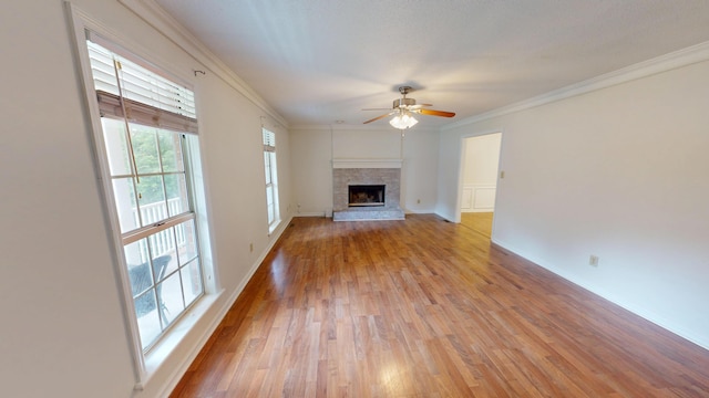 3904 Loblolly Trl, Martinez, GA 30907 - unfurnished living room featuring ceiling fan, light wood-style floors, a fireplace with raised hearth, and crown molding