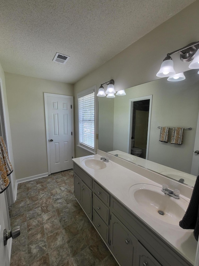 3904 Loblolly Trl, Martinez, GA 30907 - bathroom featuring double vanity, a textured ceiling, and stone finish floors