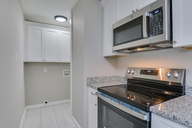 kitchen with light stone countertops, appliances with stainless steel finishes, baseboards, and white cabinets