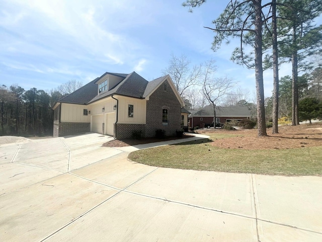 191 Devonshire Dr, Aiken, SC 29803 - view of side of property with driveway, brick siding, an attached garage, board and batten siding, and a shingled roof