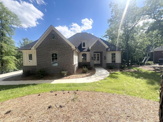 191 Devonshire Dr, Aiken, SC 29803 - french provincial home featuring brick siding, a front yard, and roof with shingles