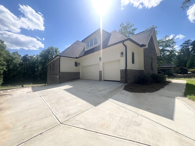 191 Devonshire Dr, Aiken, SC 29803 - view of home's exterior featuring brick siding, driveway, a shingled roof, board and batten siding, and a garage