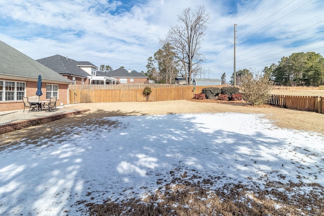 yard covered in snow with a patio