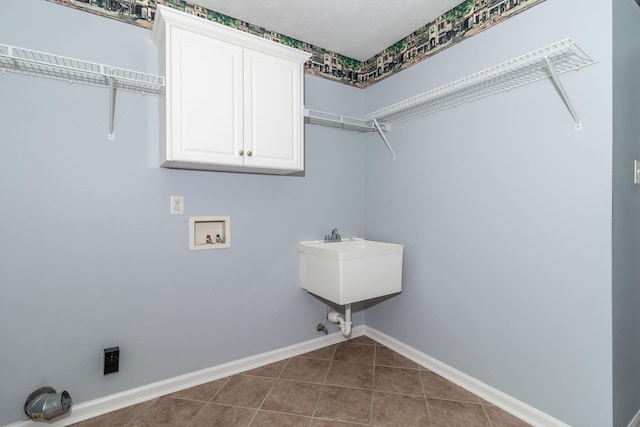 clothes washing area featuring hookup for a washing machine, tile patterned floors, and cabinets