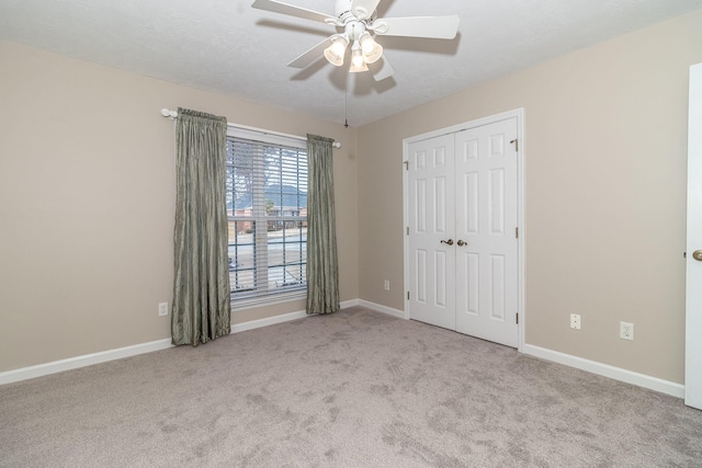 unfurnished bedroom featuring light colored carpet, a closet, and ceiling fan