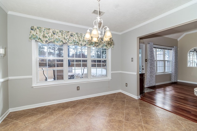 unfurnished dining area featuring crown molding, tile patterned flooring, a textured ceiling, and a notable chandelier