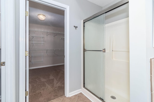 bathroom with an enclosed shower and tile patterned floors