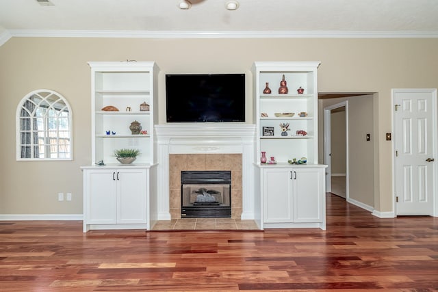 unfurnished living room featuring ornamental molding, a tile fireplace, and dark hardwood / wood-style floors