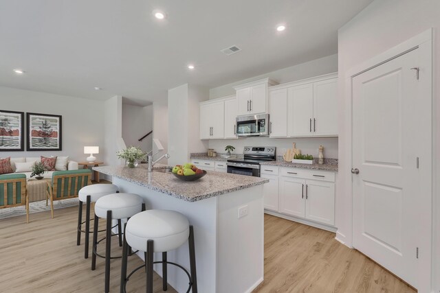 790 Count Fleet Ct, Graniteville, SC 29829 - kitchen featuring stainless steel appliances, a kitchen breakfast bar, light wood-type flooring, white cabinets, and recessed lighting