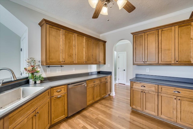kitchen featuring stainless steel dishwasher, brown cabinetry, arched walkways, a ceiling fan, and a sink