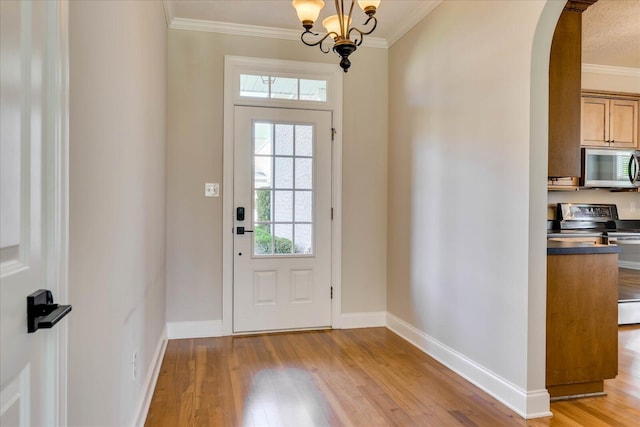 foyer featuring ornamental molding, baseboards, arched walkways, and light wood-style floors