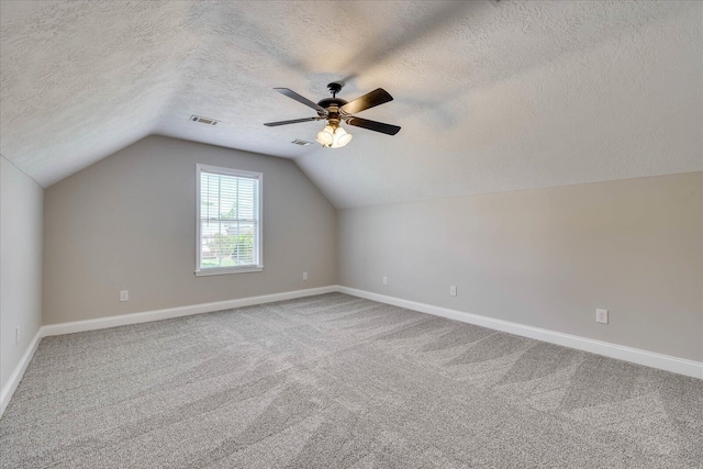 bonus room with visible vents, a textured ceiling, carpet floors, and lofted ceiling
