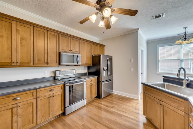 kitchen with light wood-style floors, brown cabinetry, visible vents, appliances with stainless steel finishes, and a sink