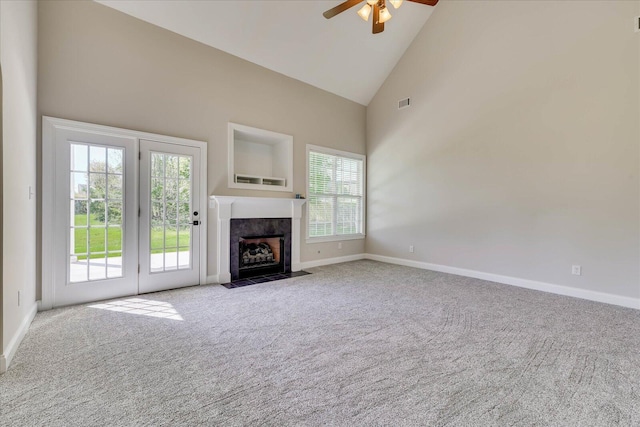 unfurnished living room featuring baseboards, a fireplace, carpet flooring, ceiling fan, and high vaulted ceiling