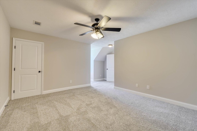 unfurnished room with visible vents, ceiling fan, light colored carpet, and baseboards