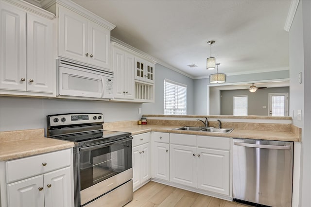 2120 Whitney S Dr, Augusta, GA 30904 - kitchen with appliances with stainless steel finishes, plenty of natural light, light wood-style flooring, ornamental molding, and white cabinetry