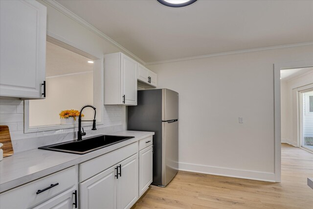 2281 Raleigh Dr, Augusta, GA 30904 - kitchen featuring a sink, freestanding refrigerator, crown molding, white cabinetry, and decorative backsplash