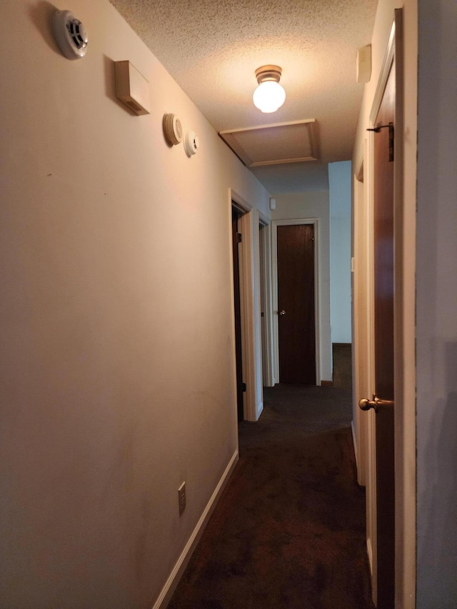 3747 Crest Dr, Hephzibah, GA 30815 - hall with attic access, a textured ceiling, and dark carpet