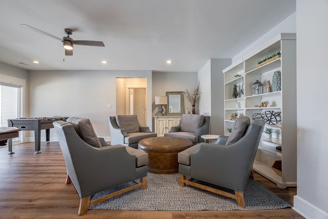 living room featuring wood-type flooring and ceiling fan