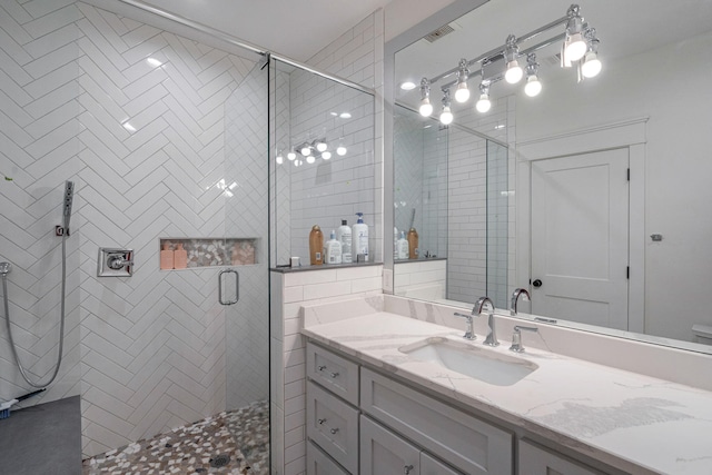 bathroom with a shower with door and vanity