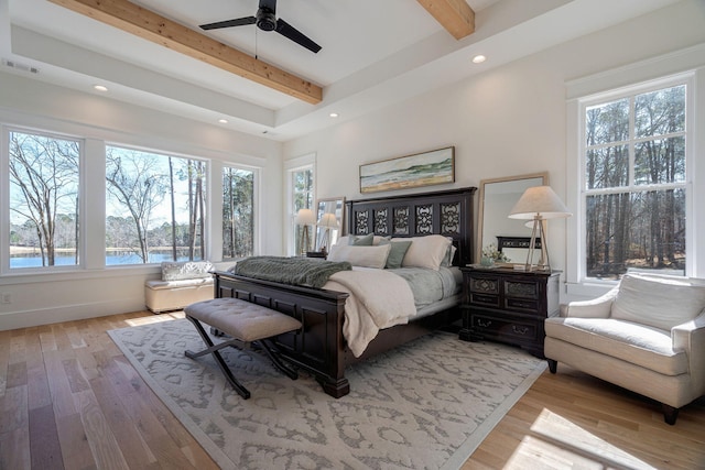 bedroom with ceiling fan, a water view, beam ceiling, and light hardwood / wood-style floors