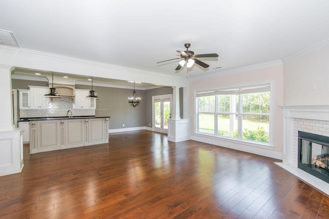 322 Pump House Rd, Evans, GA 30809 - unfurnished living room with a ceiling fan, a fireplace, a chandelier, crown molding, and dark wood-type flooring