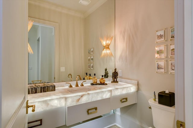 bathroom with crown molding, vanity, and toilet