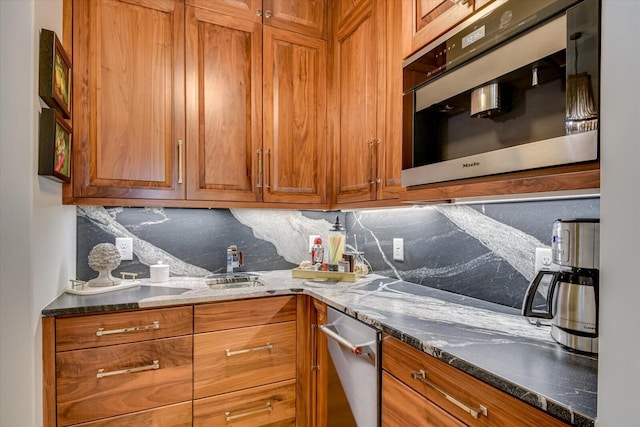 kitchen featuring dark stone counters, brown cabinetry, and backsplash