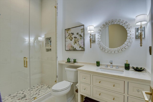 bathroom with toilet, a shower stall, and vanity