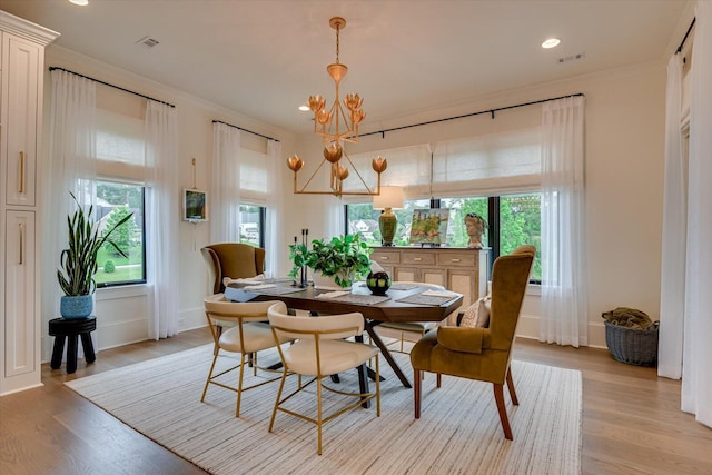 dining room featuring light wood-style floors, plenty of natural light, and a notable chandelier