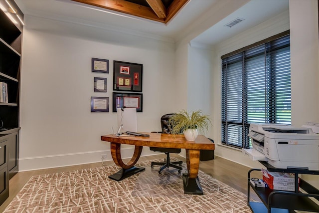 office space featuring visible vents, baseboards, crown molding, and wood finished floors