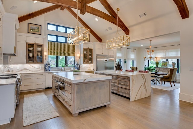 kitchen with a chandelier, light wood-style flooring, visible vents, a large island, and high end appliances