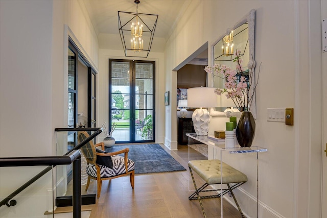 foyer entrance with a chandelier, french doors, wood finished floors, and baseboards