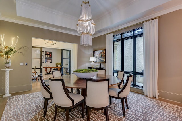 dining area featuring baseboards, a tray ceiling, and crown molding