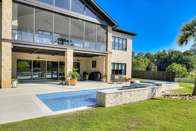 rear view of property featuring brick siding, a patio area, fence, and a balcony