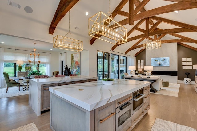 kitchen with a notable chandelier, a spacious island, visible vents, open floor plan, and a wealth of natural light