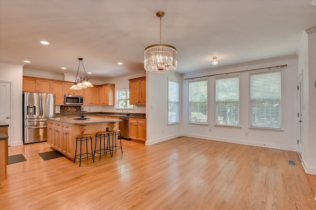920 Napiers Post Dr, Evans, GA 30809 - kitchen featuring appliances with stainless steel finishes, a center island, a kitchen bar, recessed lighting, and light wood-type flooring
