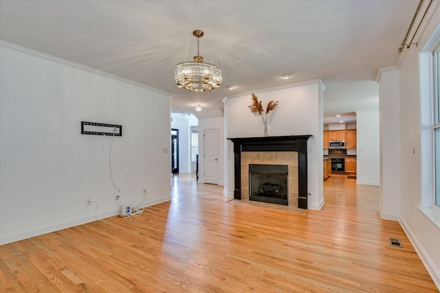 920 Napiers Post Dr, Evans, GA 30809 - unfurnished living room featuring light wood-type flooring, crown molding, a chandelier, and a tiled fireplace