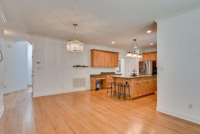 920 Napiers Post Dr, Evans, GA 30809 - kitchen with stainless steel fridge with ice dispenser, light wood finished floors, crown molding, a kitchen bar, and a chandelier