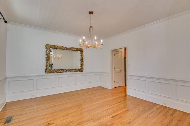 920 Napiers Post Dr, Evans, GA 30809 - unfurnished room with a chandelier, ornamental molding, light wood finished floors, a decorative wall, and a wainscoted wall