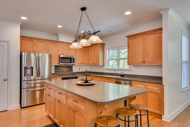 920 Napiers Post Dr, Evans, GA 30809 - kitchen with appliances with stainless steel finishes, light wood-type flooring, a center island, a kitchen bar, and dark countertops