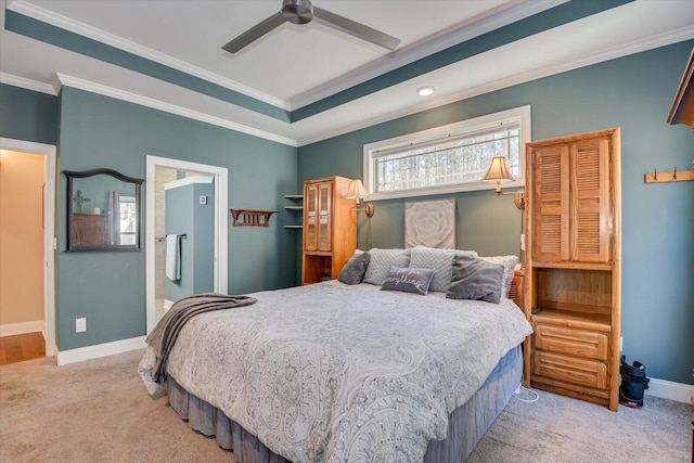 carpeted bedroom featuring a tray ceiling, baseboards, ceiling fan, and crown molding