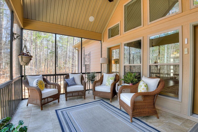 sunroom / solarium featuring plenty of natural light, wood ceiling, and lofted ceiling