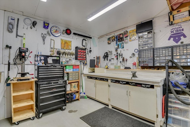 miscellaneous room with a workshop area and concrete flooring