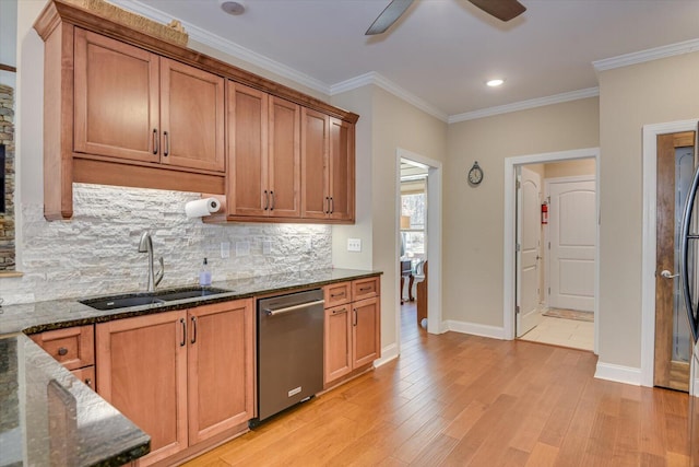 kitchen with dark stone countertops, dishwasher, light wood-style floors, and a sink